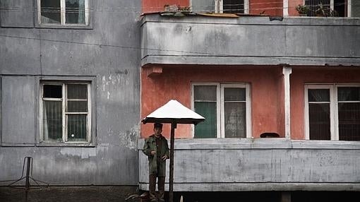 Un soldado vigila una obra en una calle secundaria de Pyongyang, en la que deben trabajar los propios vecinos dentro de las brigadas ciudadanas organizadas por el régimen