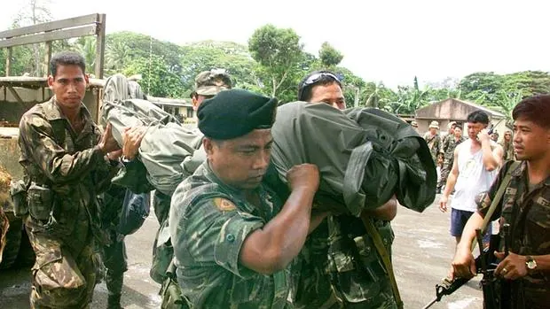 Militares filipinos trasladan el cadáver de un compañero muerto en enfrentamientos con Abu Sayyaf