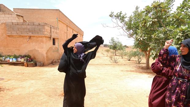 Imagen de la libertad: una mujer se quita el niqab, símbolo de la opresión del Daesh, tras la liberación de su pueblo