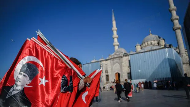 Un hombre vende banderas turcas, junto a la mezquita de Eminou, en Estambul