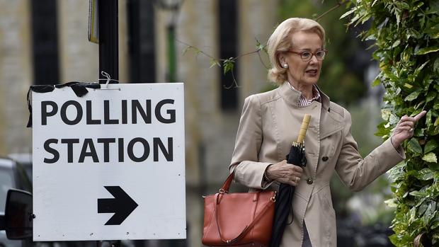 Jubilados de la armada británica salen tras votar en un colegio electoral en Londres