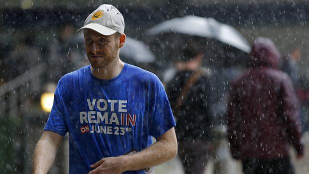 Un hombre partidario de la permanencia del Reino Unido en la UE camina este jueves, jornada electoral lluviosa, por el centro de Londres