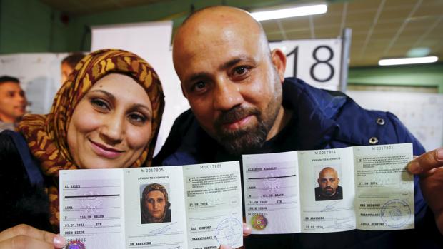 Wafy Al-Hamoud Alkhaldy, 36, y su mujer, Asma Al Saleh, 33, de la ciudad siria de Deir ez-Zor muestran su documento de registro para inmigrantes tras obtenerlo en Herford, Alemania el 22 de Febrero de este año
