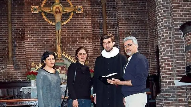 Tres conversos iraníes con un pastor luterano en la iglesia Apostelkirken de Copenhague - Journal de Genève