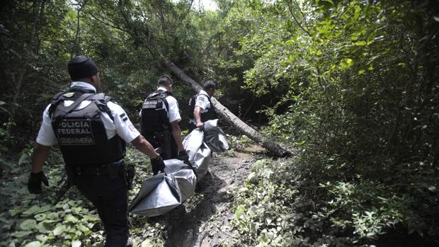 Policías federales trasladan el cadáver de un asesinado cerca de Acapulco