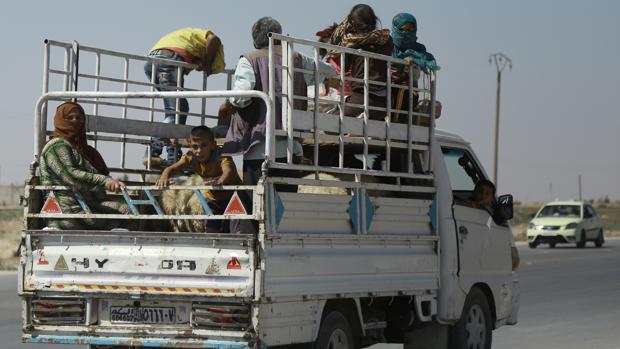 Varios civiles sirios huyen de la ciudad de Hasaka ayer tras el comienzo de los combates