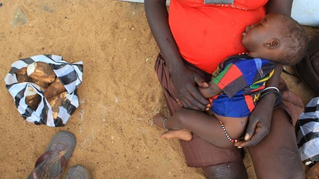 Una mujer sostiene a su hijo en un centro de acogida en Sudán del Sur