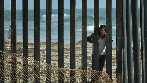 Un hombre mira hacia los EE.UU. desde el lado mexicano de la fronteriza en San Diego, California
