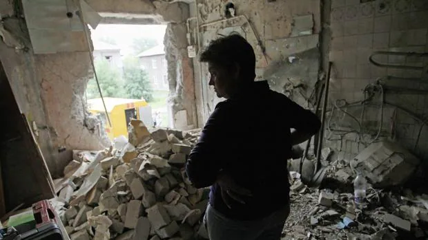 Una mujer observa los escombros en el interior de su casa tras por un bombardeo en Gorlovka, en el area de Donestsk, Ucrania, este jueves