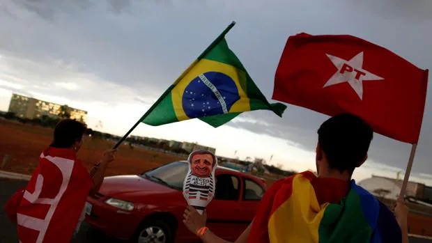 Varias personas ondean la banderas brasileña y del Partido de los Trabajadores en apoyo a Dilma Rousseff