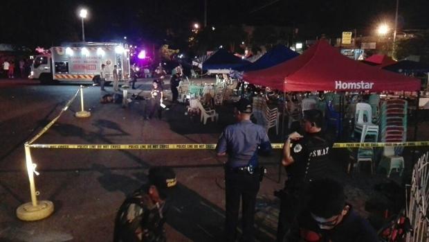 Un policía del Departamento Operativo de Escena de Crímen (SOCO) vigila mientras se recogen evidencias en el sitio donde hubo una explosión en un mercado nocturno en Dávao, Filipinas