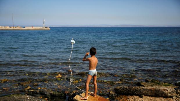 Un niño sirio juega junto al mar en el campo de refugiados de Souda, en la isla griega de Quíos