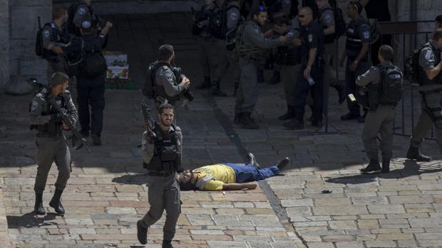 Policías rodean el cuerpo sin vida de un joven abatido a tiros tras presuntamente atacar con un cuchillo a agentes junto a la muralla de la ciudad vieja en Jerusalén (Israel)