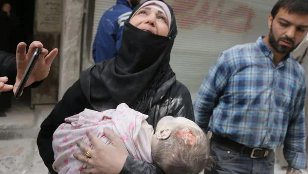 Una mujer siria, desesperada, carga el cuerpo de su bebé rescatado de los escombros, tras el bombardeo sobre el área al-Muasalat, en Alepo