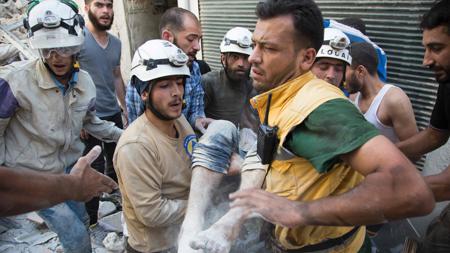 Miembros de los equipos de rescate conocidos como «Cascos blancos» trasladan a un herido recuperado de los escombros que causó el bombardeo sobre un distrito rebelde de Alepo