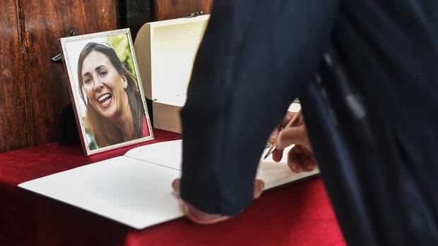 Un hombre firma en el libro de condolencias durante el funeral de María Villar