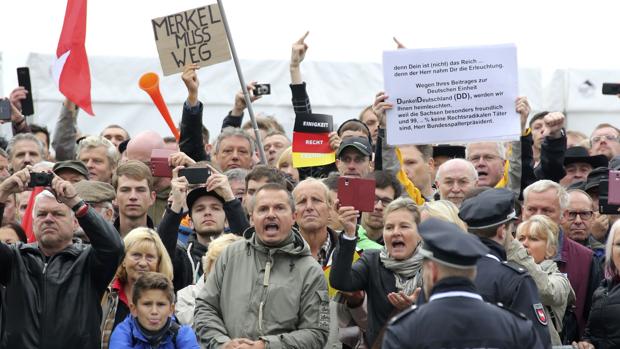 Manifestantes piden la renuncia de la canciller Merkel, durante la fiesta de la unidad alemana, este lunes en Dresde