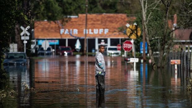 Un hombre permanece de pie en una calle inundada como resultado del paso del huracán Matthew en Fair Bluff, Carolina del Norte