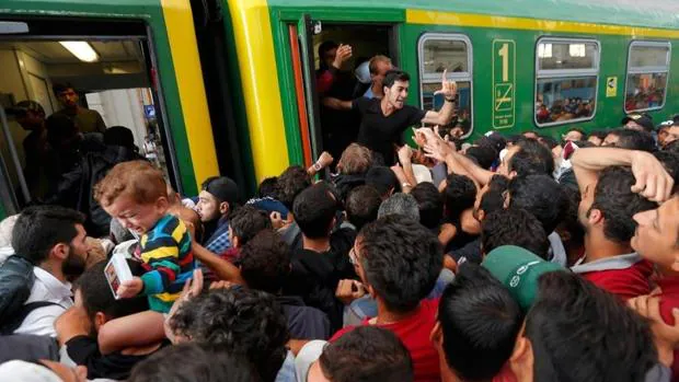 Refugiados en la estación de Budapest intentan subir a un tren para llegar a Austria