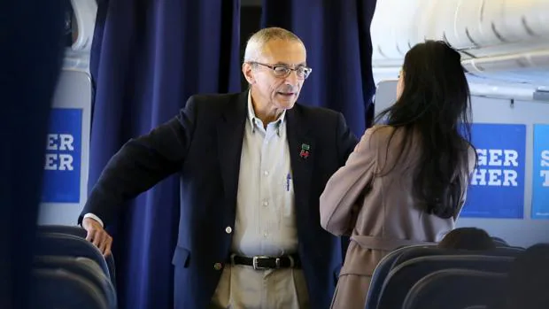 El jefe de la campaña de Clinton conversa con una asesora en el avión de la candidata