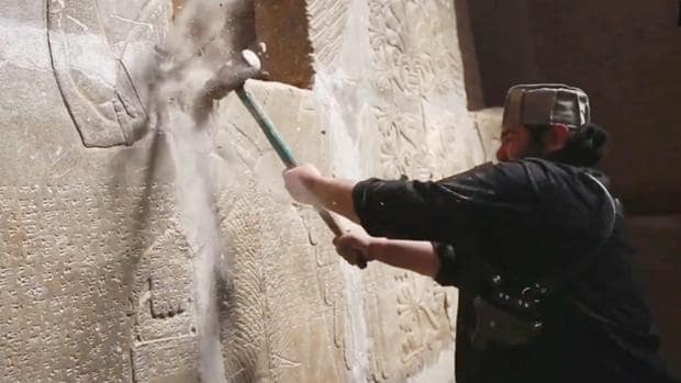Un miembro de Daesh destruye un friso de Nimrad