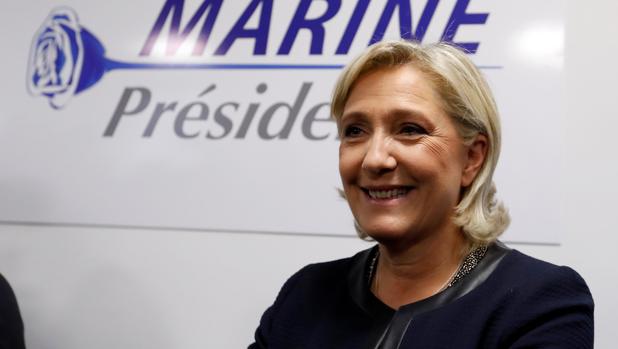 La líder del Frente Nacional francés, Marine Le Pen, delante del cartel de la campaña electoral de su partido