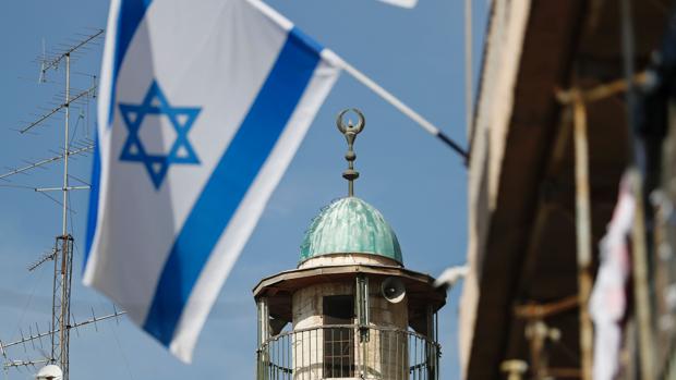 La bandera de Israel ondea junto al minarete de una mezquita en el barrio árabe de la ciudad vieja de Jerusalén
