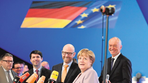 Merkel y otros miembros de la CDU conversan con la prensa en la víspera del congreso del partido, en Essen