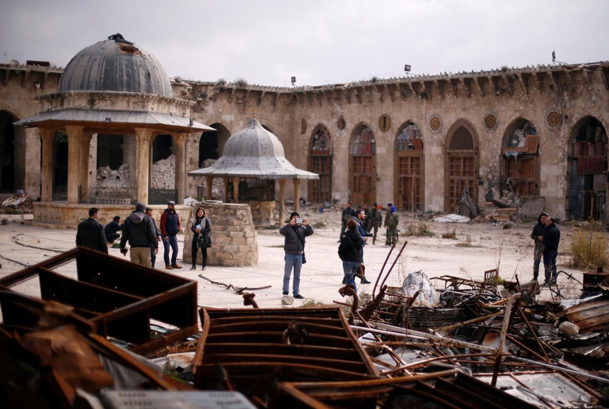 Algunas personas visitaron ayer la Gran Mezquita de Alepo, dañada por los bombardeos