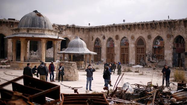 Algunas personas visitaron ayer la Gran Mezquita de Alepo, dañada por los bombardeos