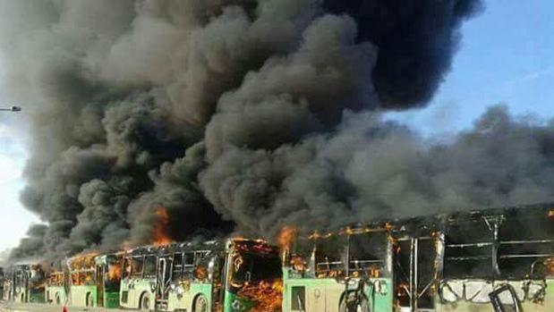 Vista de una hilera de autobuses en llamas donde iban a ser evacuados enfermos y heridos de Fua y Kefraya