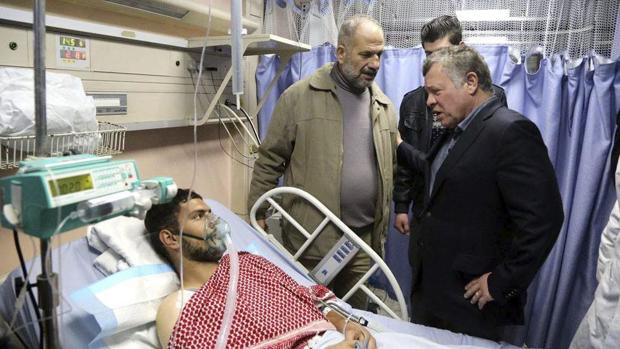 El rey Abdullah II (d) mientras visita a uno de los heridos en un tiroteo acontecido el domingo en la ciudad de Karak, en Amán, Jordania