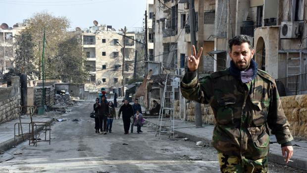Un soldado sirio hace la señal de victoria en un barrio del este de Alepo