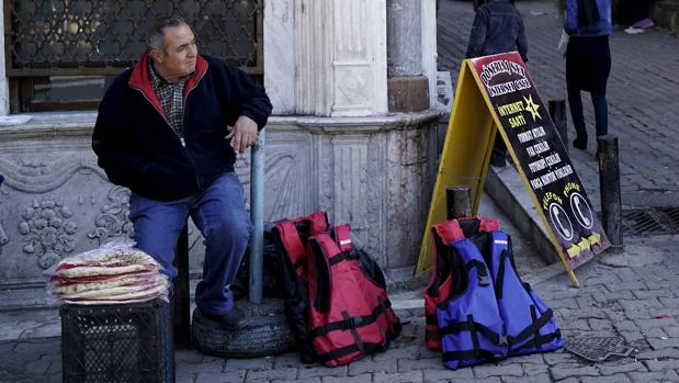 Un vendedor de chalecos para inmigrantes en una calle de Esmirna (Turquía)