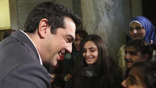 El primer ministro griego, Alexis Tsipras (i), se reúne con un grupo de menores refugiados no acompañados y con familias en situación de especial vulnerabilidad, en vísperas de Navidad en Atenas