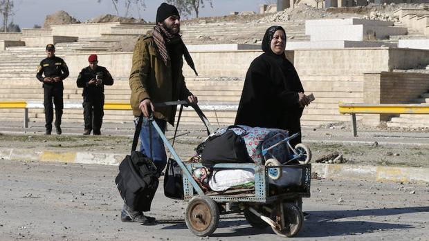 Dos civiles huyen de los enfrentamientos en la ciudad iraquí de Mosul