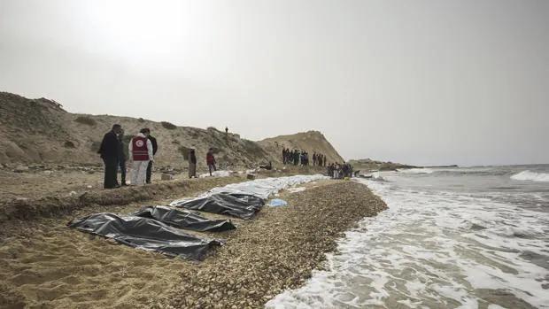 Miembros de la Cruz Roja recogen los cadáveres de al menos 74 personas tras un naufragio frente a las costas de Libia