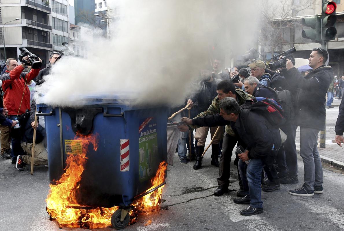 Varisos ganaderos prenden fuego a un contenedor de basura durante una protesta de ganaderos contra la reforma fiscal y de las pensiones ante el Ministerio de Agricultura en Atenas