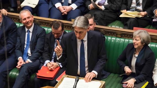 Imagen de la Cámara de los Comunes en la que a primera ministra británica, Theresa May, escucha al canciller británico Philip Hammond entregar su declaración sobre el presupuesto de primavera en la Cámara de los Comunes