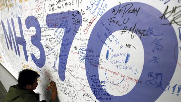 Imagen de archivo de 2014 de un hombre que escribe un mensaje para los pasajeros desaparecidos en el MH370