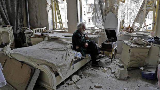 Mohammed Mohiedine Anis, de 70 años, contempla las ruinas de su casa mientras fuma de su pipa