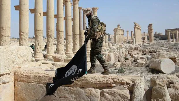 Imagen de archivo de un soldado sirio quita una bandera del «califato» en las ruinas