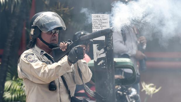 Un agente policial reprime este lunes a los participantes en una protesta en Caracas