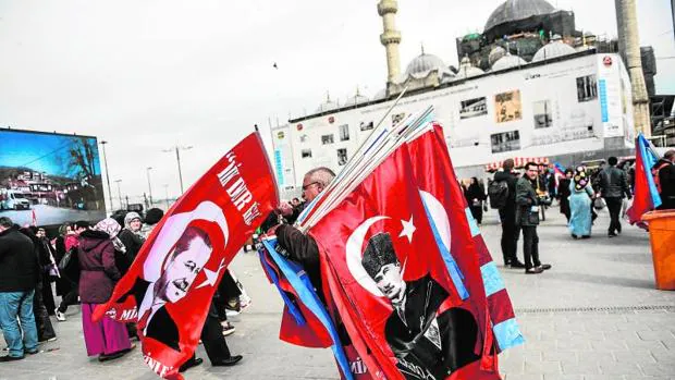 Un vendedor con banderas turcas, con la imagen de Ataturk o Erdogan, durante un acto de la campaña del referéndum a favor del sí, este miércoles en Estambul