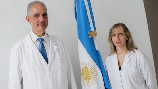Fotografía cedida por CONICET, de los investigadores Carlos Della Védova y Rosana Romano junto a la bandera de Argentina.
