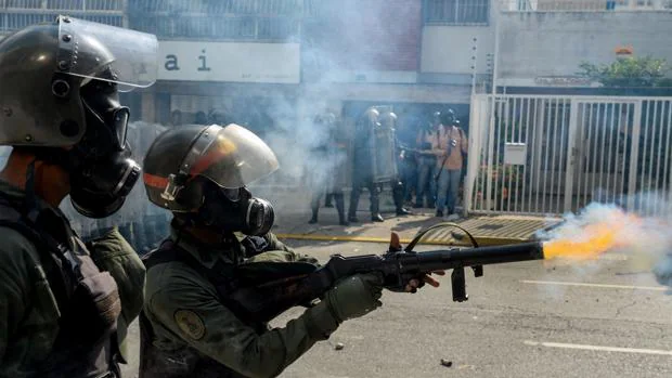 Miembros de las fuerzas de seguridad cargan contra una protesta en Caracas