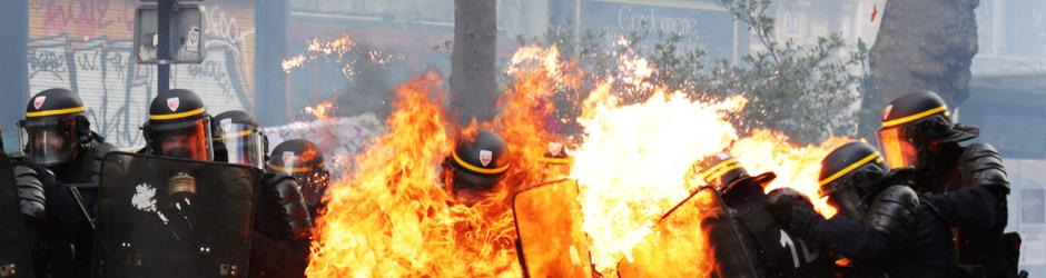 Policías franceses antidisturbios envueltos en llamas durante los enfrentamiento de París por el Primero de Mayo