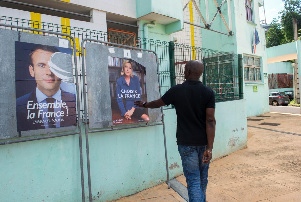 Un hombre pasa ante unos carteles de los candidatos presidenciales