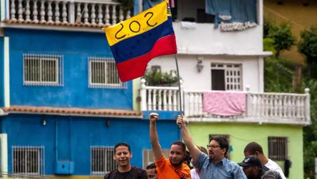 Freddy Guevara, vicepresidente de la Asamblea Nacional (c-d), sostiene una bandera durante una manifestación el sábado en Caracas