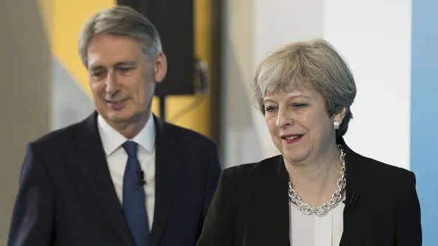 Theresa May junto a su ministro de Economía, Philip Hammond